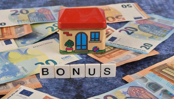 Casa in miniatura, scritta "bonus" e banconote euro