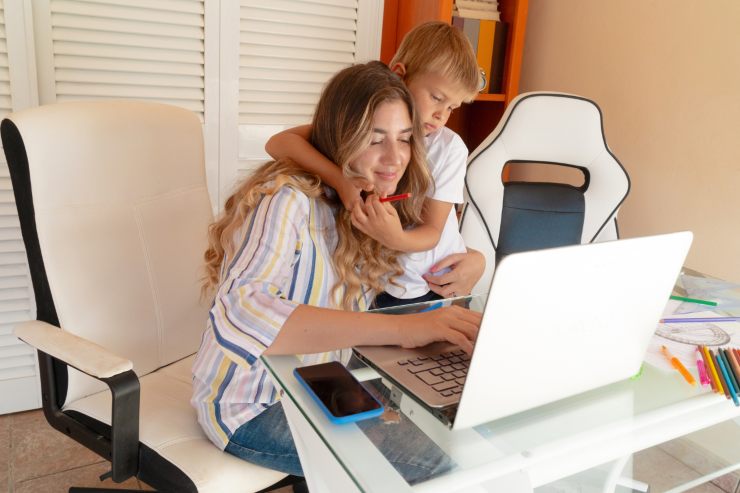 Mamma al pc e bambino che l'abbraccia