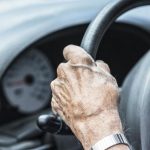 Mano di un'anziana al volante