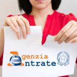 Donna che strappa un foglio dei debiti con logo dell'Agenzia delle Entrate